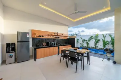 a kitchen with a table and a refrigerator and a counter at Aleksa - Villa with Rooftop&Rice Field View in Canggu