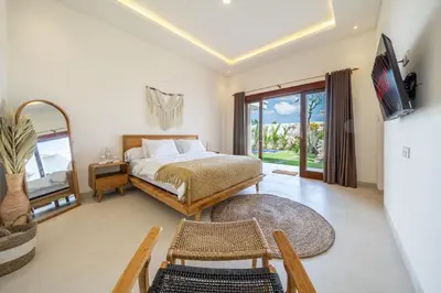 a bedroom with a bed and a table and a tv at Aleksa - Villa with Rooftop&Rice Field View in Canggu