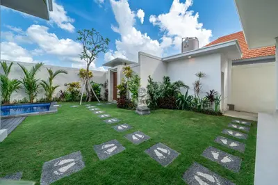a garden with a lawn in front of a house at Aleksa - Villa with Rooftop&Rice Field View in Canggu