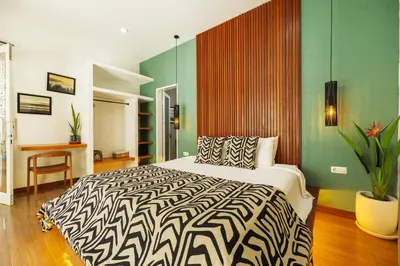 a bedroom with a bed with a black and white comforter at Villa Karibu Canggu-2BR with pool & rooftop in Canggu