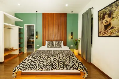 a bedroom with a bed and a painting on the wall at Villa Karibu Canggu-2BR with pool & rooftop in Canggu