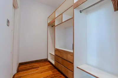 a walk in closet with wooden shelves and a mirror at Villa Chloe by Pertama Management in Seminyak