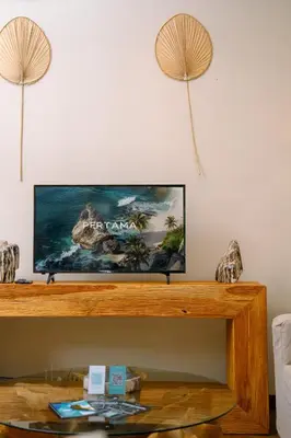 a flat screen tv sitting on top of a wooden table at Villa Chloe by Pertama Management in Seminyak