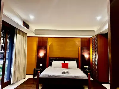 a bedroom with a bed with a red pillow at Jimbaran Cozy Stay in Jimbaran