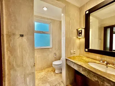 a bathroom with a toilet and a sink and a mirror at Jimbaran Cozy Stay in Jimbaran