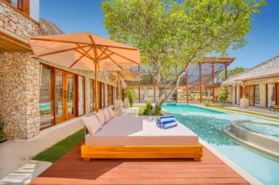 an outdoor patio with an umbrella and a swimming pool at Villa Vienna - New 8BDR Jacuzzi Sauna and Cinema in Seminyak
