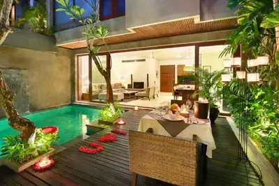 a house with a swimming pool and a dining table at Amani Entire 2 BR Private Pool Villa in Seminyak