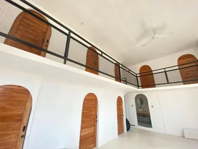 a staircase in a house with wooden doors at WIJA's Bali Homestay in Legian