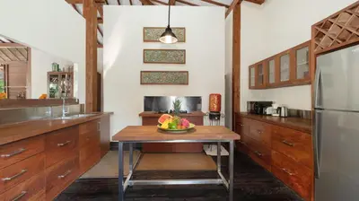 a kitchen with a table with a bowl of fruit on it at Desa Roro Estate by Villa Finder in Canggu