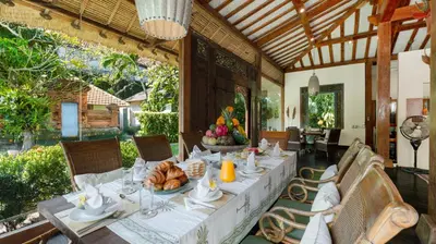 a dining room with a table with food on it at Desa Roro Estate by Villa Finder in Canggu