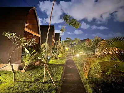 a path through a garden at night with lights at Yogasari Villa Seminyak in Seminyak