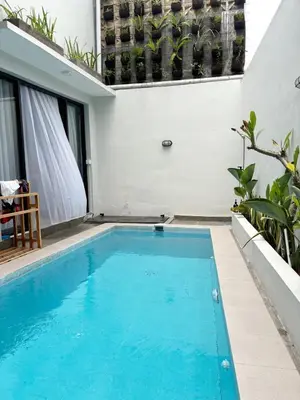 a swimming pool in the middle of a house at Peaceful Private 4 BR YY Bali Villa, Jimbaran Nusa Dua, In Central Kuta in Jimbaran