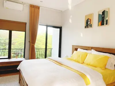 a bedroom with a large bed with yellow pillows at Peaceful Private 4 BR YY Bali Villa, Jimbaran Nusa Dua, In Central Kuta in Jimbaran