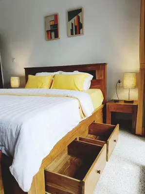 a bedroom with a large bed with a wooden frame at Peaceful Private 4 BR YY Bali Villa, Jimbaran Nusa Dua, In Central Kuta in Jimbaran