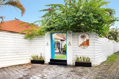 a white building with a blue door and a tree at 3 Bedrooms Luxury Umalas with private pool in Kerobokan