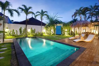 a swimming pool in a backyard with palm trees at 3 Bedrooms Luxury Umalas with private pool in Kerobokan