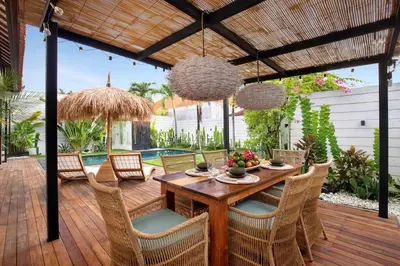 a wooden deck with a wooden table and chairs at 3 Bedrooms Luxury Umalas with private pool in Kerobokan