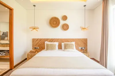 a bedroom with a large bed and two baskets on the wall at Brand New 4br Villa 400 to Finns Canggu in Canggu