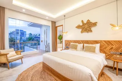 a bedroom with a large bed and a balcony at Brand New 4br Villa 400 to Finns Canggu in Canggu