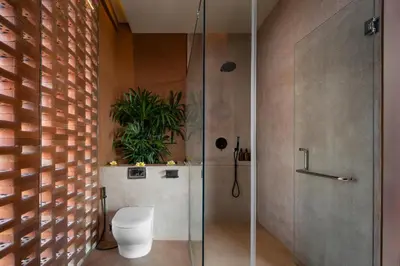 a bathroom with a shower with a toilet and a plant at Kula Terra One Bedroom Villa in Kerobokan
