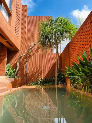 a swimming pool in front of a building with a palm tree at Kula Terra One Bedroom Villa in Kerobokan