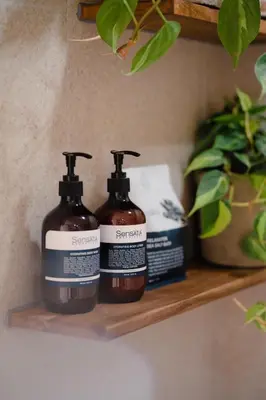 two bottles of soap sitting on a shelf at Sunset Suites, 1 bed apartment, Jayakarta hotel in Seminyak