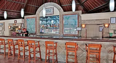 a woman sitting at a bar in a restaurant at Sunset Suites, 1 bed apartment, Jayakarta hotel in Seminyak