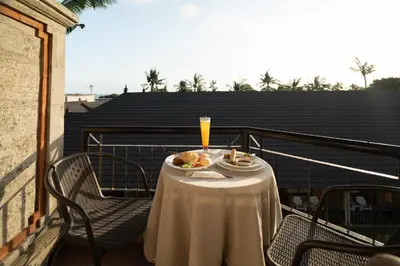 a table with food and a drink on a balcony at Sunset Suites, 1 bed apartment, Jayakarta hotel in Seminyak