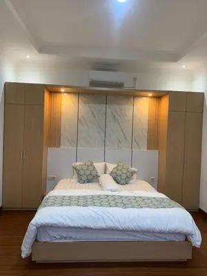 a bedroom with a large bed with wooden cabinets at Wikans Villa in Kuta