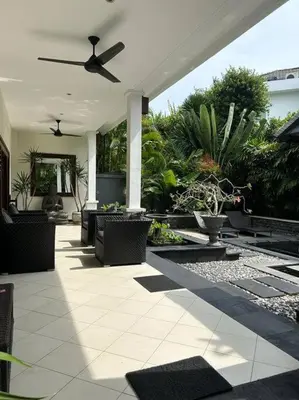 an outdoor patio with a ceiling fan and plants at Villa Teratai in Seminyak