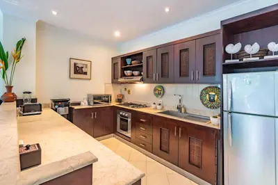 a large kitchen with wooden cabinets and a refrigerator at Villa Teratai in Seminyak