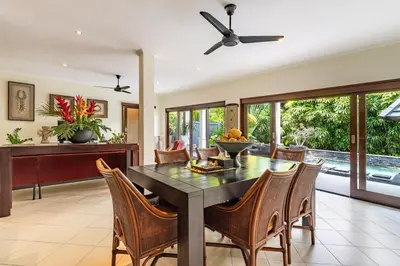 an open kitchen and dining room with a table and chairs at Villa Teratai in Seminyak