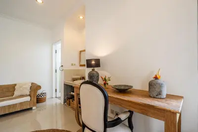a home office with a wooden desk and a chair at Kupu-Kupu Villa by iBali Management in Canggu