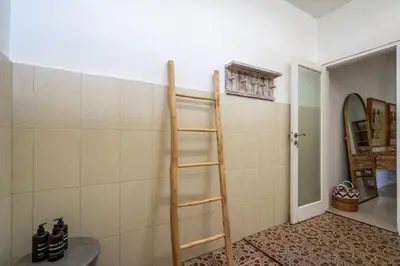 a bathroom with a wooden ladder on the wall at Kupu-Kupu Villa by iBali Management in Canggu