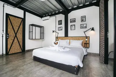 a bedroom with a large white bed and a door at Villa Costa Plana - 2 bedroom industrial private villa in Umalas, between Canggu & Seminyak in Seminyak