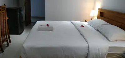 a large white bed with two red crosses on it at WJ Guest house in Kerobokan