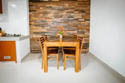 a dining room table with chairs and a brick wall at Villa Umah Seminyak in Seminyak