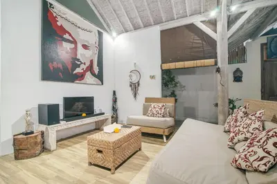 a living room with a bed and a couch and a tv at Villa Laksmana 1 in Canggu