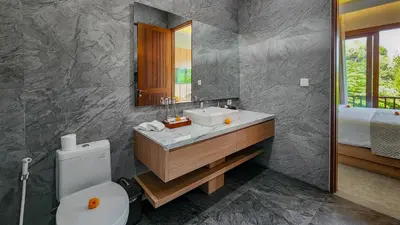 a bathroom with a sink and a toilet and a mirror at Casa De Gracia Sanur Beach by Nagisa Bali in Sanur
