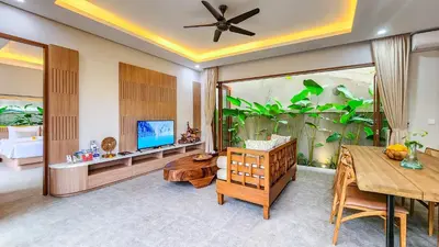 a living room with a large fishtank in the background at Casa De Gracia Sanur Beach by Nagisa Bali in Sanur