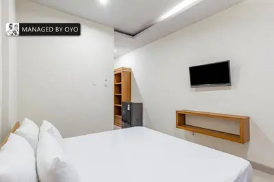 a white bedroom with a bed and a tv at Collection O Near Seminyak Beach Formerly The Kumpi Hotel in Seminyak