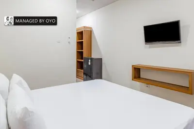 a bedroom with a bed and a tv on a wall at Collection O Near Seminyak Beach Formerly The Kumpi Hotel in Seminyak