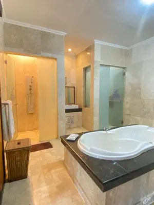 a large bathroom with a tub and a shower at Private Pool Classic Villa in Kuta