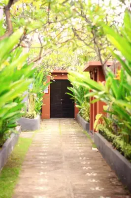 a driveway leading to a garage with a black door at Private Pool Classic Villa in Kuta