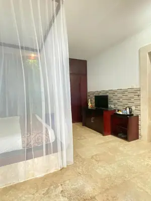 a bedroom with a bed and a window with a television at Private Pool Classic Villa in Kuta