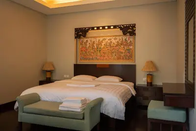 a bedroom with a bed with a tapestry on the wall at Bali Stile villa in Nusa Dua