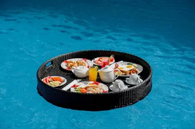 a table of food in a basket in the water at The Pandan Sari Hotel in Jimbaran