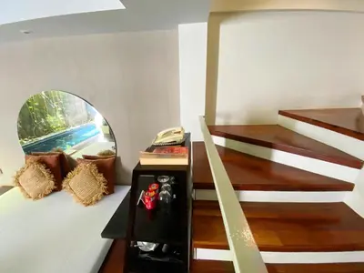 a room with stairs and a mirror on the wall at Venus Private Pool Kuta By iLys Collection in Kuta