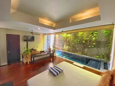a large aquarium in the middle of a living room at Venus Private Pool Kuta By iLys Collection in Kuta