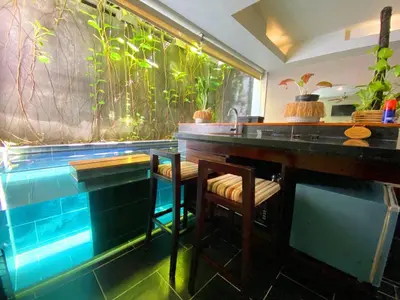 a bar with a fish tank in a room at Venus Private Pool Kuta By iLys Collection in Kuta